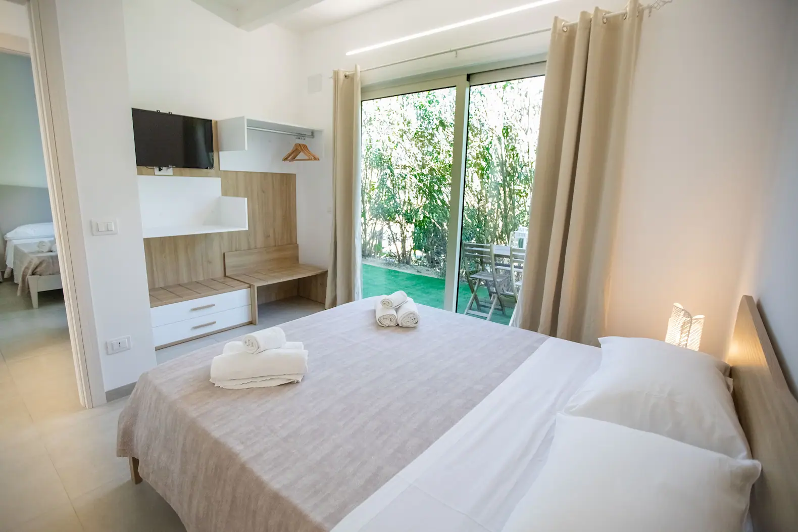 Camera da Letto con Ampia Vetrata e Area Riservata Esterna.