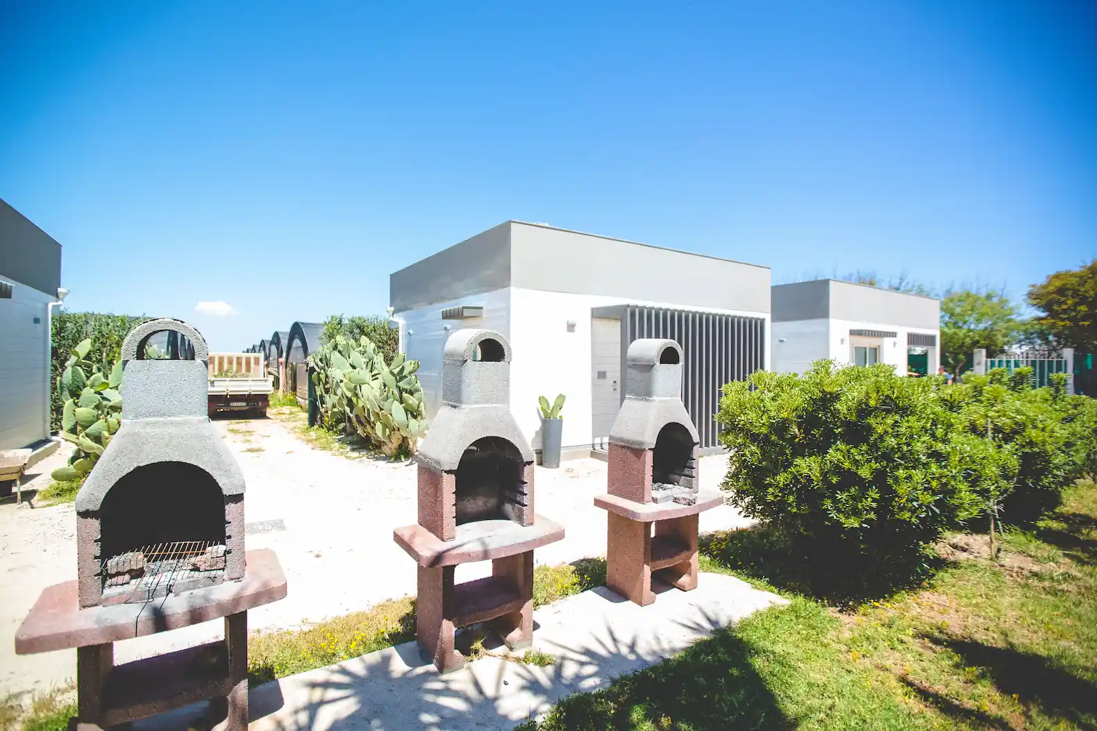 Area Barbecue nel Glamping in Sicilia: 3 barbecue in pietra davanti alle casette.